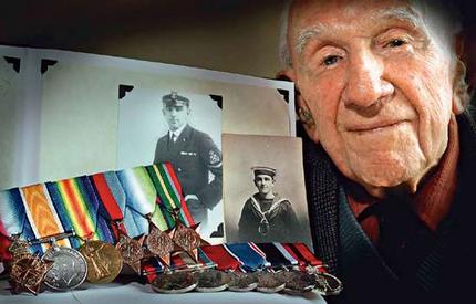 Memories  On his 100th birthday in 1999, Evan Allan poses
with the service medals he won in both world wars and with pictures
of him as a young sailor and petty officer.