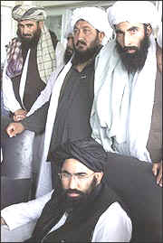 Afghan Ambassador to Pakistan Abdul Salam Zaeef seated in front of Taliban militia members. Source/AP Photos